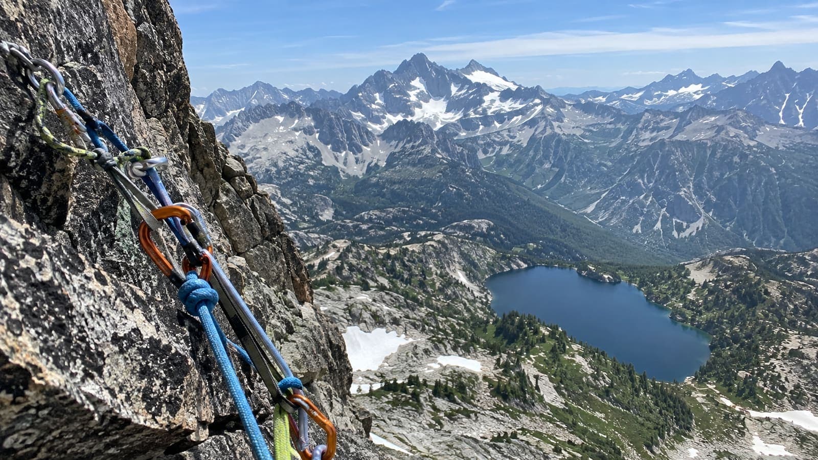 Relais d'escalade, mousquetons et cordes, au-dessus d'un lac de montagne